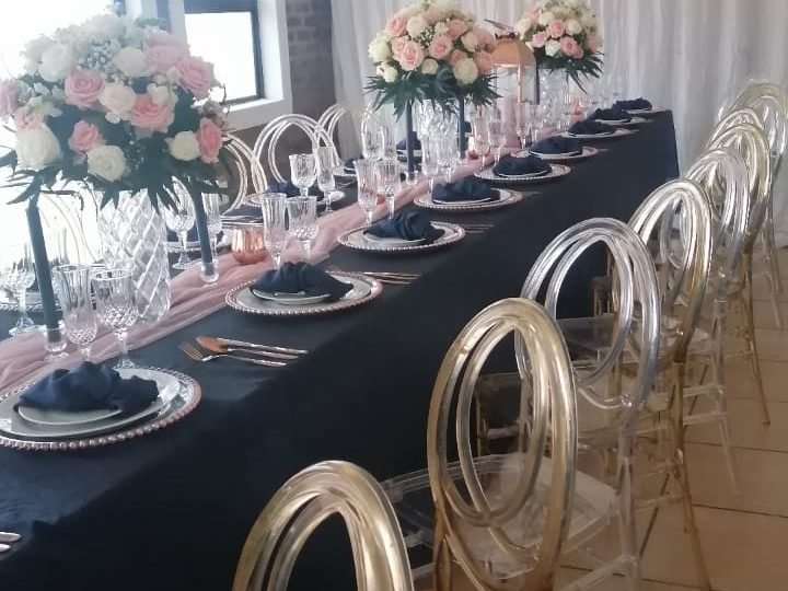Long banquet table set with navy linen and gold chiavari chairs
